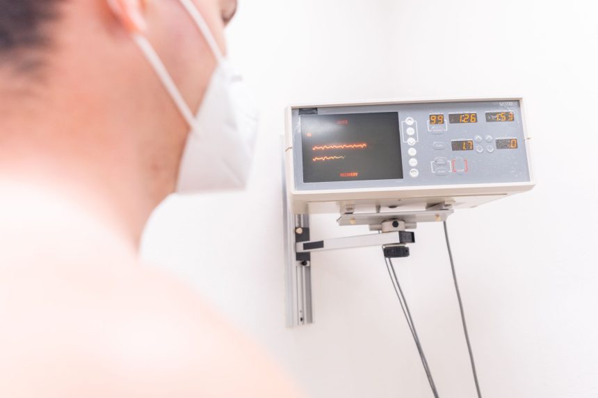 Paciente usando máscara é monitorado por equipamento eletrônico em uma clínica.