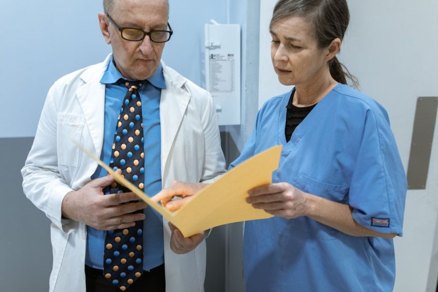 Médico e enfermeira analisam prontuários de pacientes em um ambiente clínico.