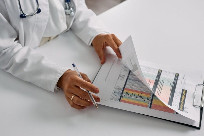 Profissional de saúde analisa relatórios médicos em uma prancheta, em um consultório.