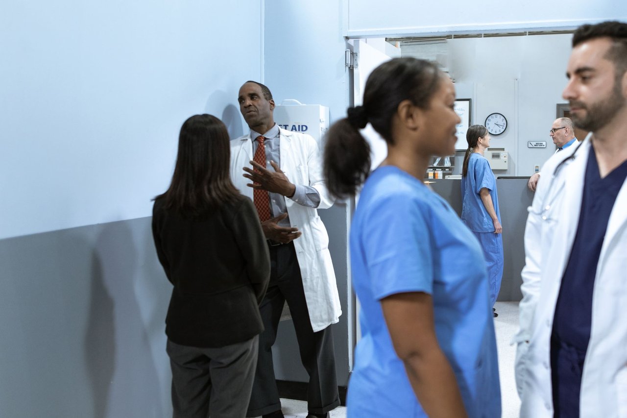 Médicos e enfermeiros conversam em um ambiente hospitalar.