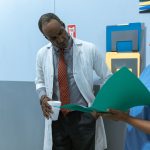 Médicos e enfermeira analisam prontuários e conversam em um ambiente hospitalar.