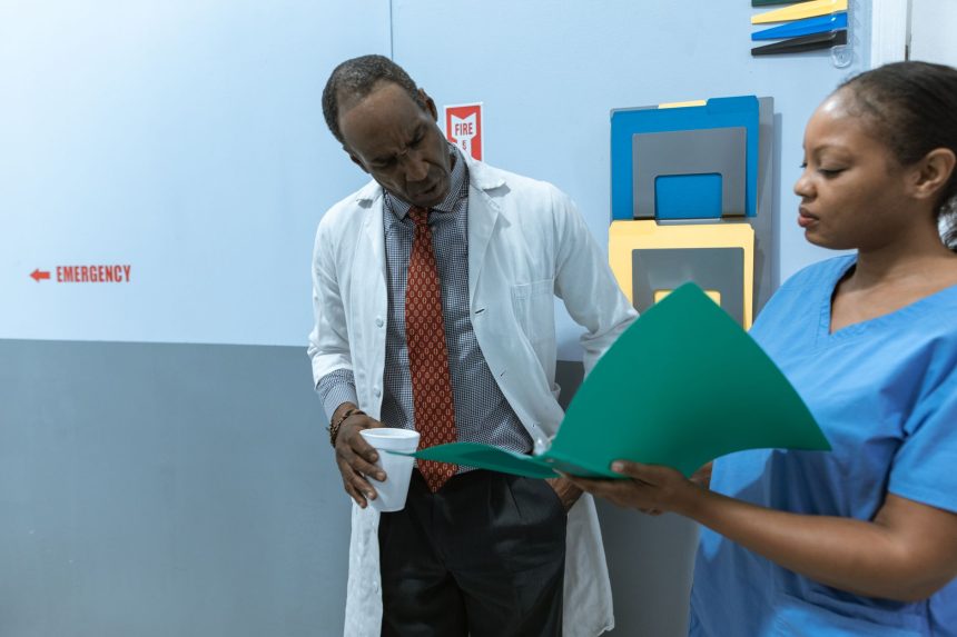 Médicos e enfermeira analisam prontuários e conversam em um ambiente hospitalar.