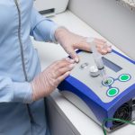 Profissional de saúde utiliza um dispositivo médico em ambiente clínico.